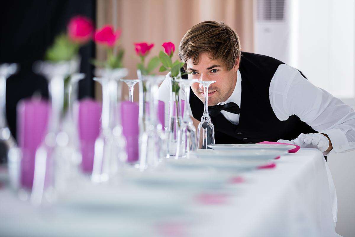 Waiter Looking At Table Arrangement